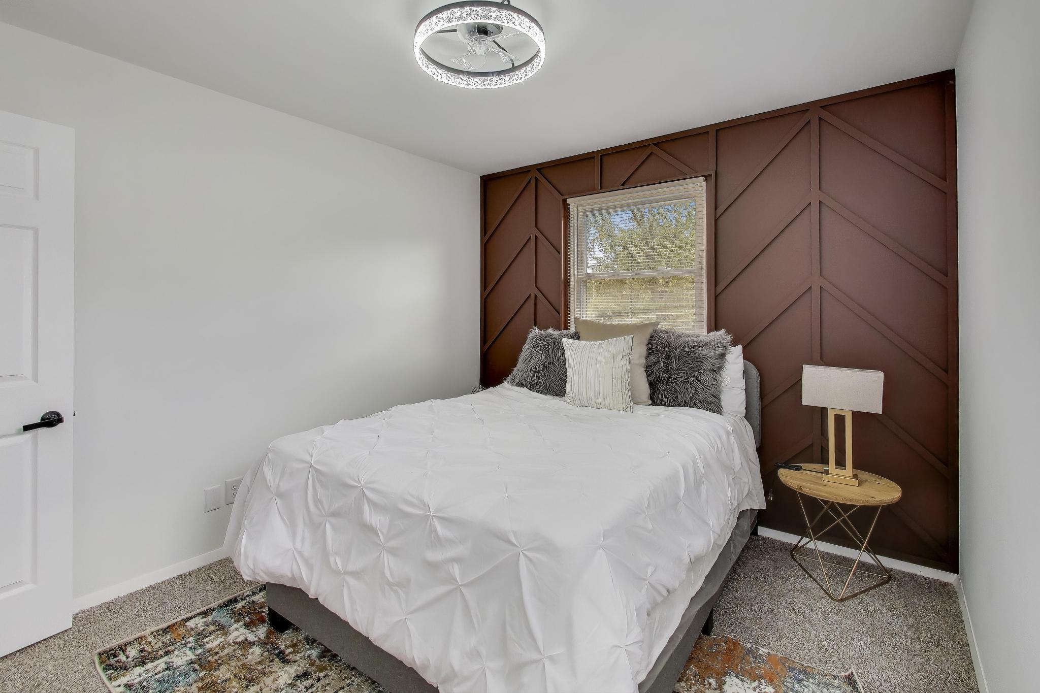 1124 Clinton Street Gary, IN 46406 - Photo 31 of 52 a bedroom with a bed and a lamp next to a window