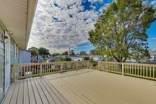 a view of backyard with a deck and wooden floor