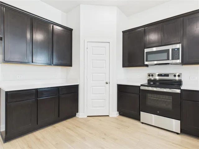 a kitchen with a refrigerator stove and microwave