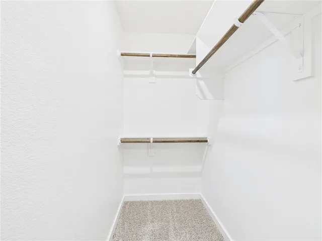 a view of walk in closet with empty racks