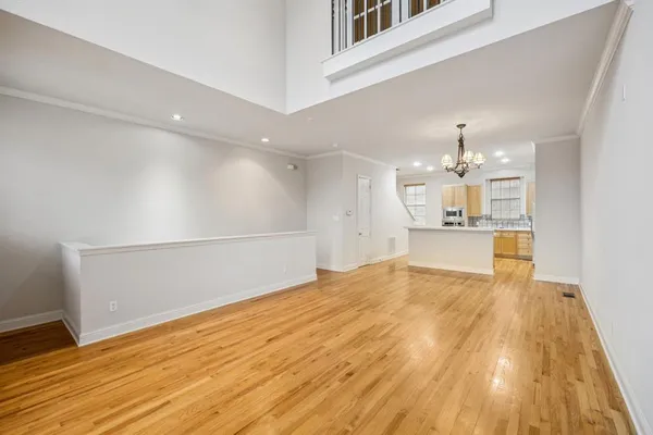 a view of a kitchen with kitchen island wooden floor center island and stainless steel appliances
