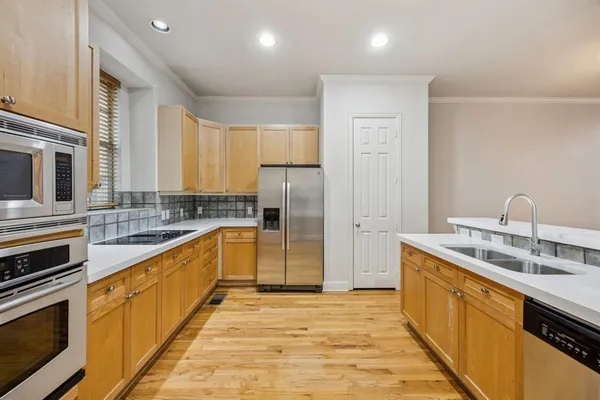 a large kitchen with stainless steel appliances granite countertop a sink and cabinets