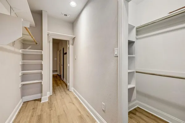 a view of walk in closet with empty racks