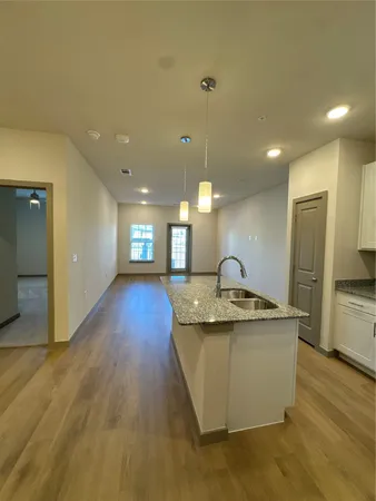 a view of a kitchen with a sink and refrigerator