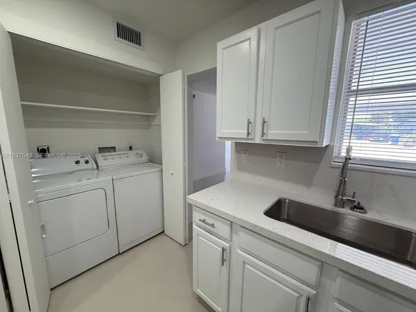 a utility room with sink dryer and washer