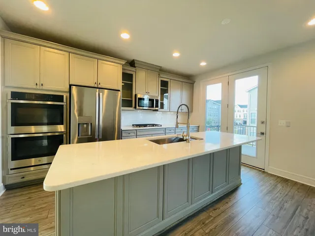 a large kitchen with kitchen island a sink stainless steel appliances and cabinets