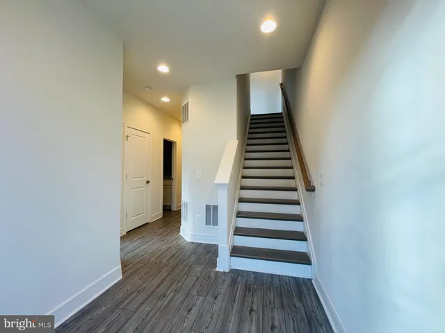 a view of a hallway with wooden floor and entryway