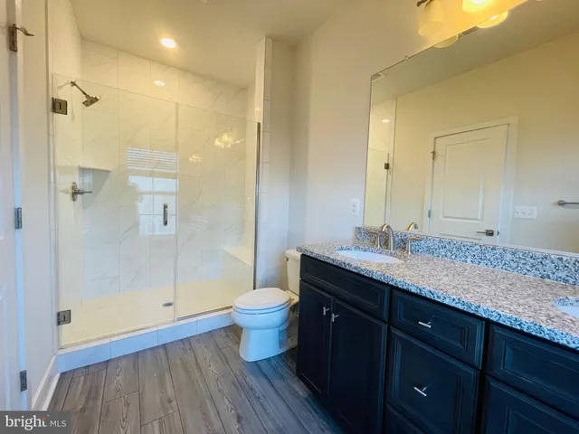 a bathroom with a granite countertop sink toilet and shower