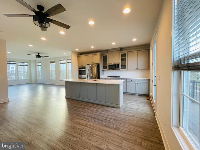 a view of kitchen with kitchen island wooden floors stainless steel appliances
