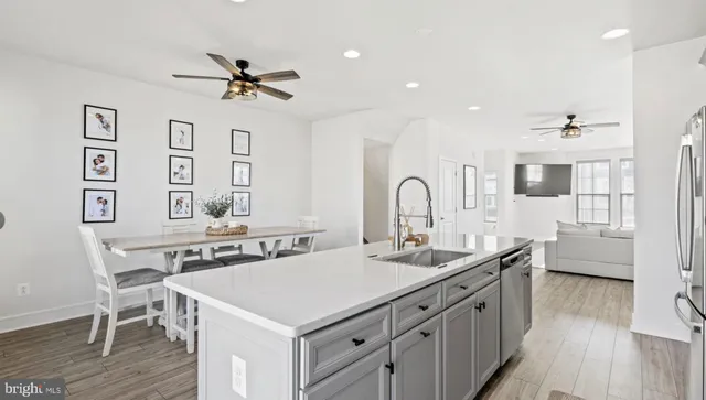 a view of a a kitchen counter space a sink wooden floor and appliances