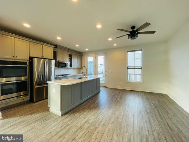 a kitchen with stainless steel appliances a refrigerator sink and microwave