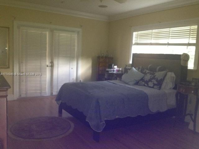 4825 Granada Boulevard Coral Gables, FL 33146 - Photo 6 of 8 a bedroom with a bed and a mirror