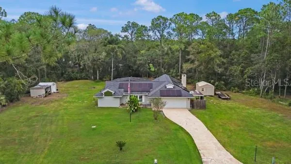 an aerial view of a house with a garden and trees