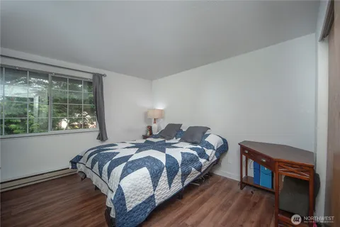 a bedroom with a bed and wooden floor
