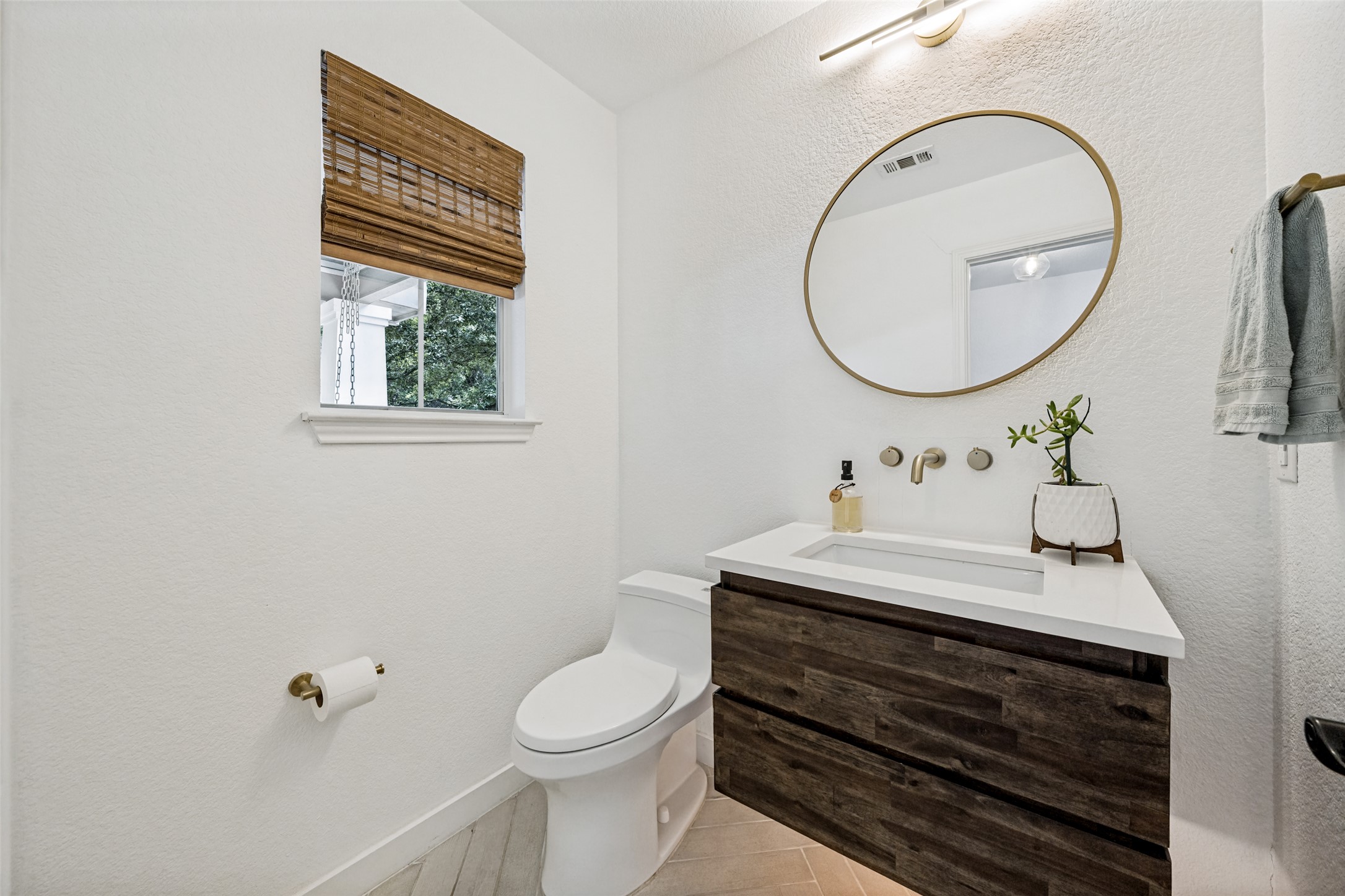9205 Rowlands Sayle Road Austin, TX 78744 - Photo 20 of 25 A compact yet well-appointed powder room features a modern floating vanity and stylish wall-mounted faucet.