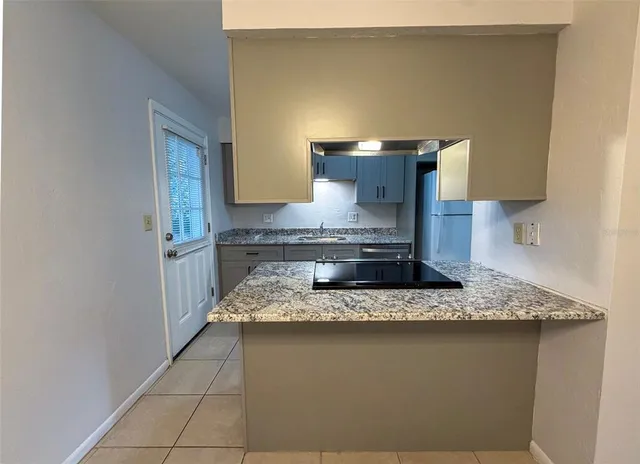 a kitchen with a stove and a granite counter tops