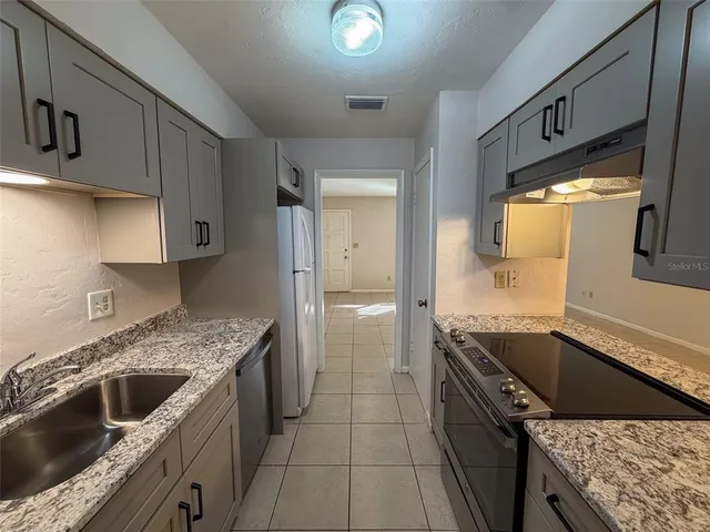 a kitchen with stainless steel appliances granite countertop a sink and a stove