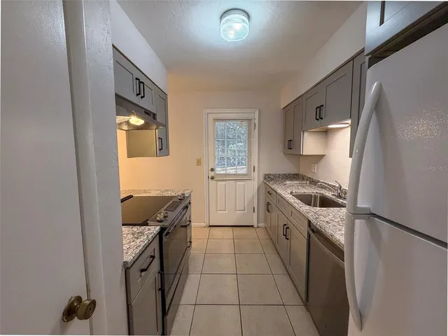 a kitchen with a stove a refrigerator and a sink