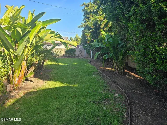 a view of a house with a yard and sitting area