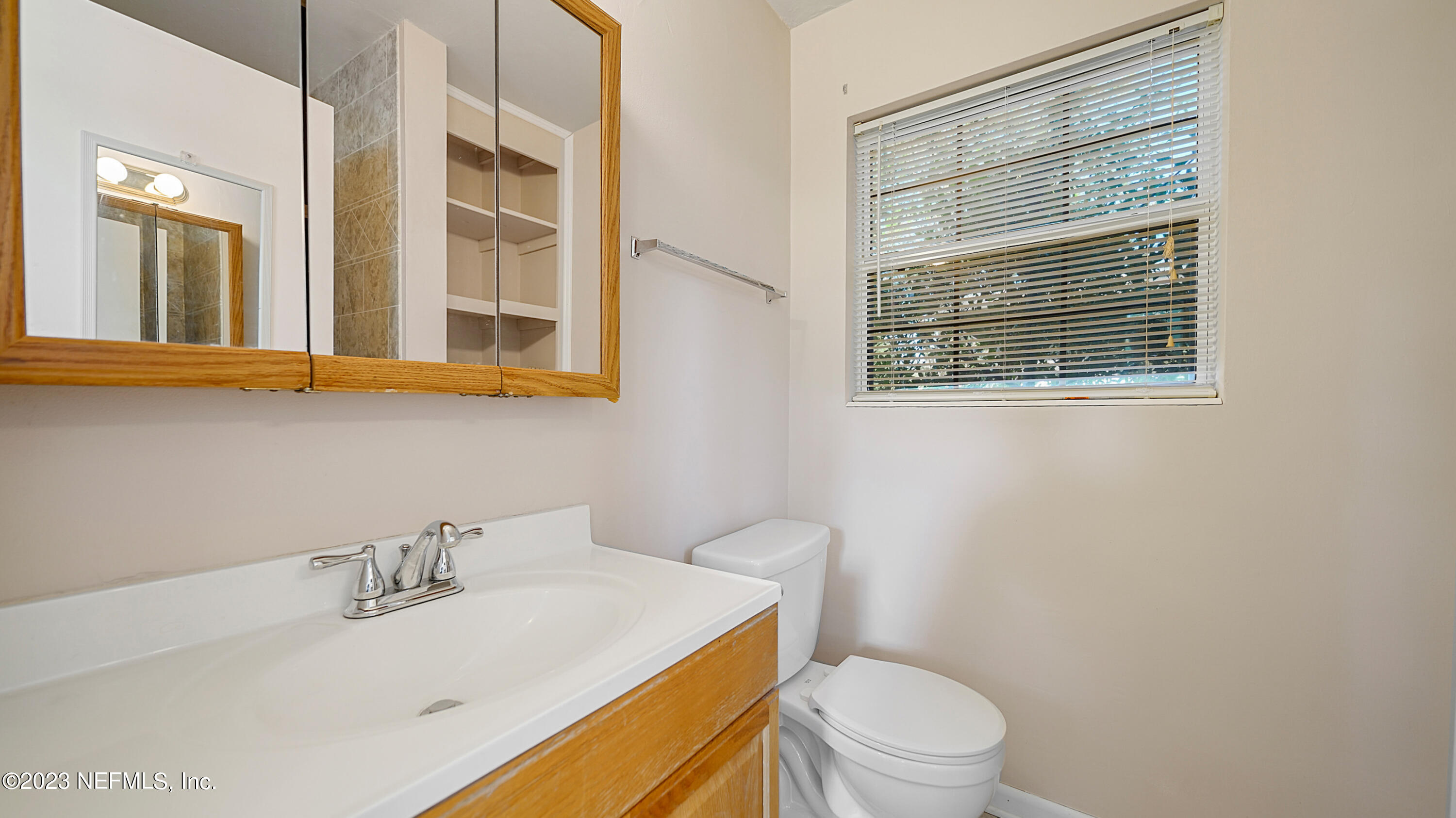 7057 Rollo Road Jacksonville, FL 32205 - Photo 17 of 30 a bathroom with a sink a toilet and a mirror