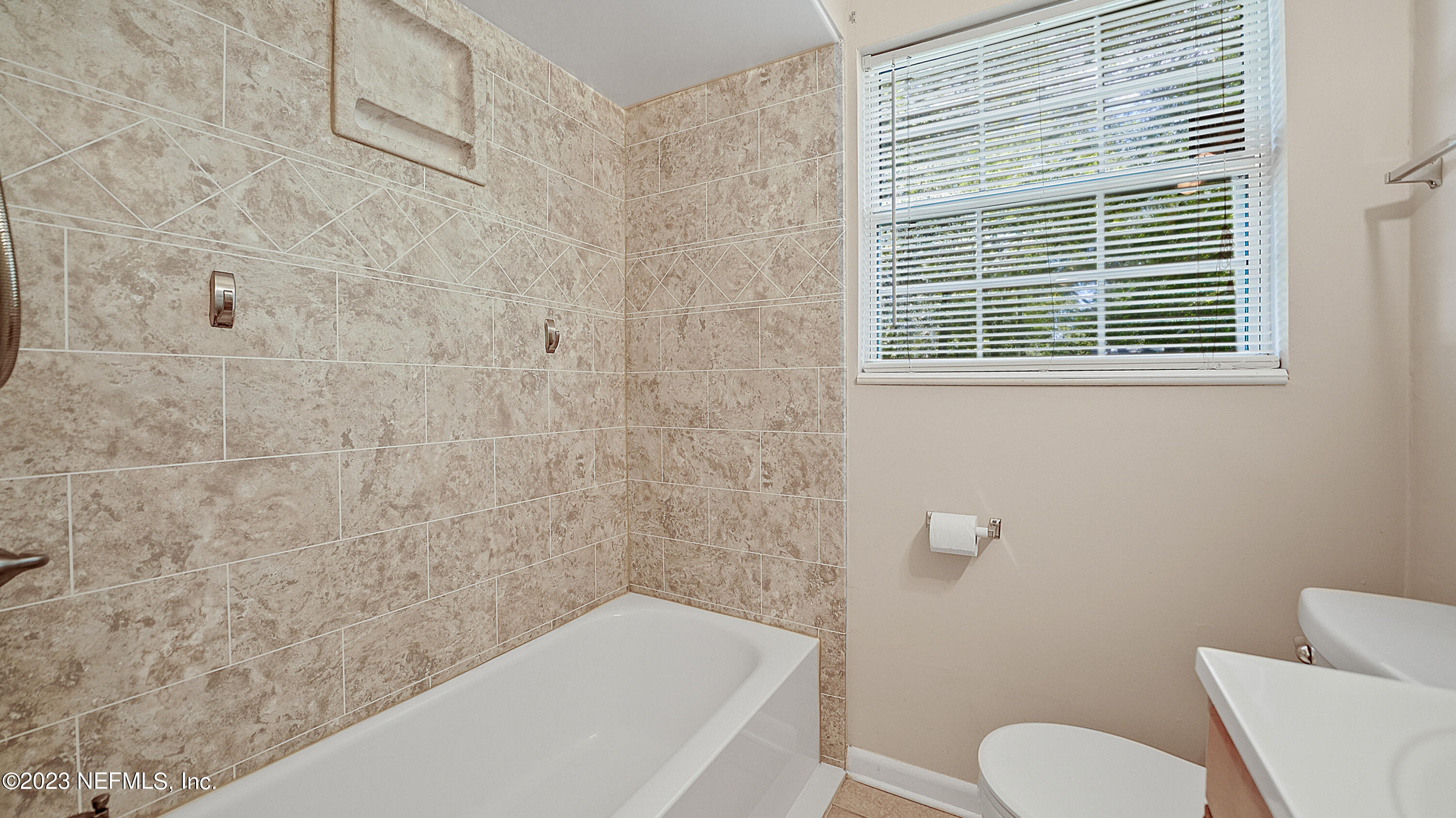 7057 Rollo Road Jacksonville, FL 32205 - Photo 22 of 30 a bathroom with a toilet and a bathtub