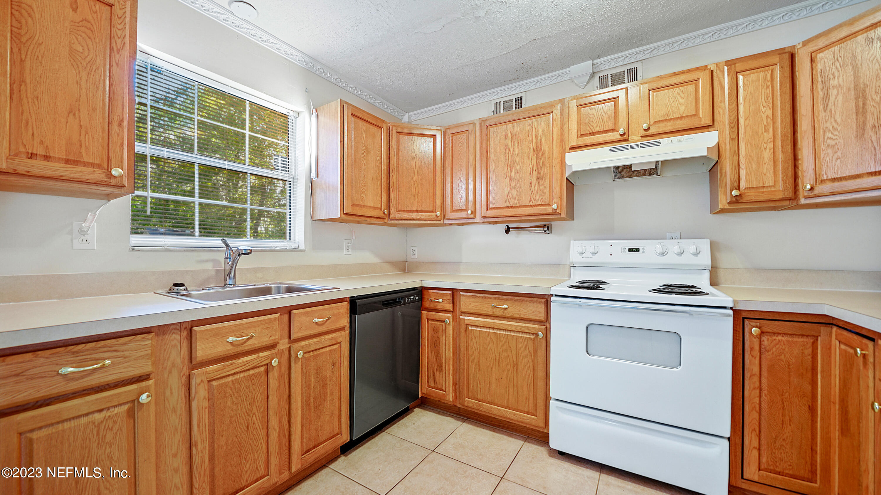 7057 Rollo Road Jacksonville, FL 32205 - Photo 5 of 30 a kitchen with cabinets appliances a sink and a window