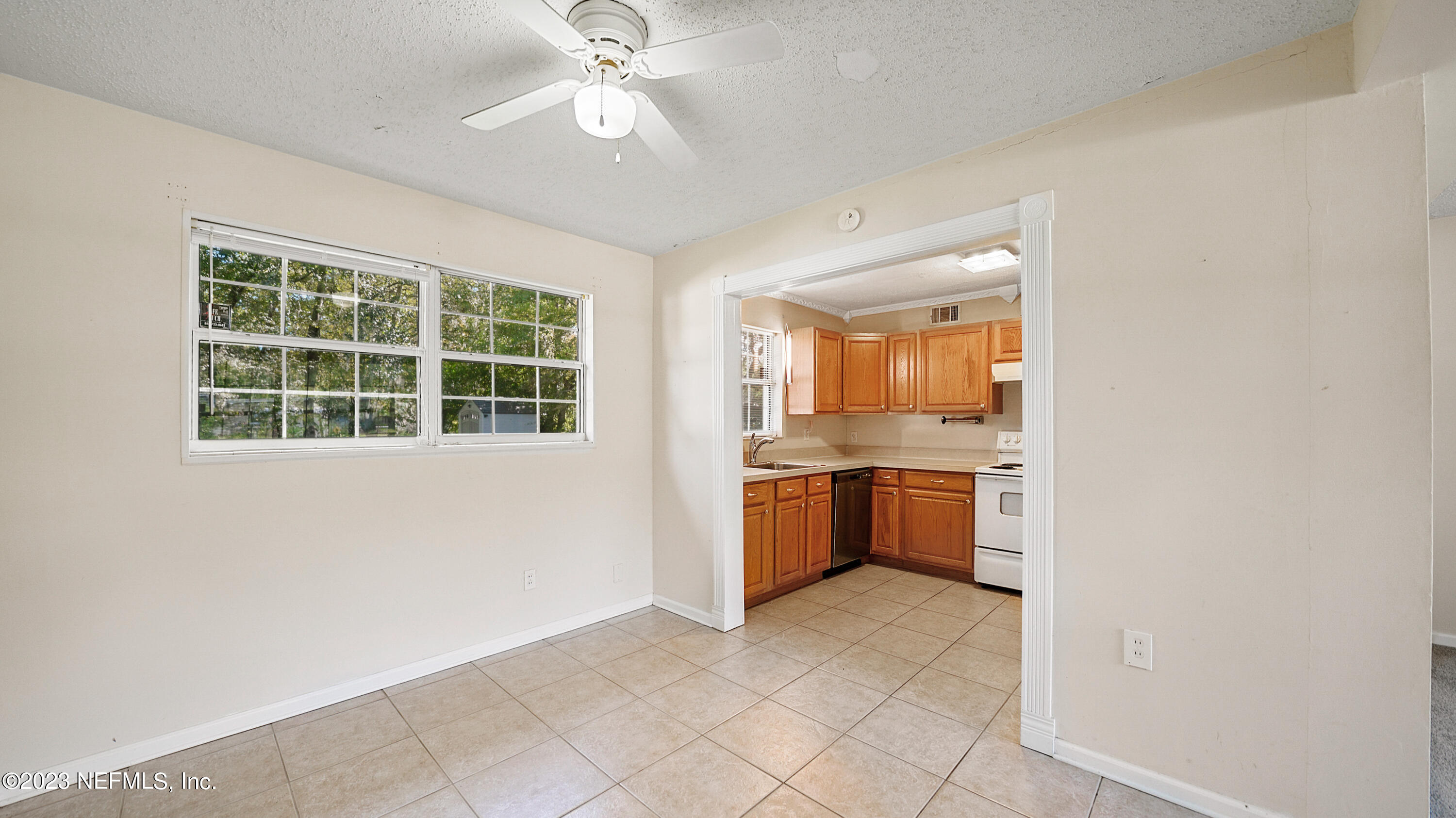 7057 Rollo Road Jacksonville, FL 32205 - Photo 7 of 30 a view of a kitchen with a sink and dishwasher a refrigerator with white cabinets