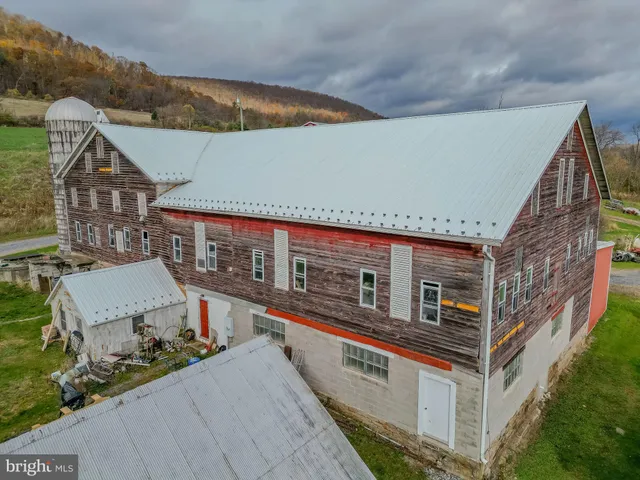 an aerial view of a house with pool and a yard