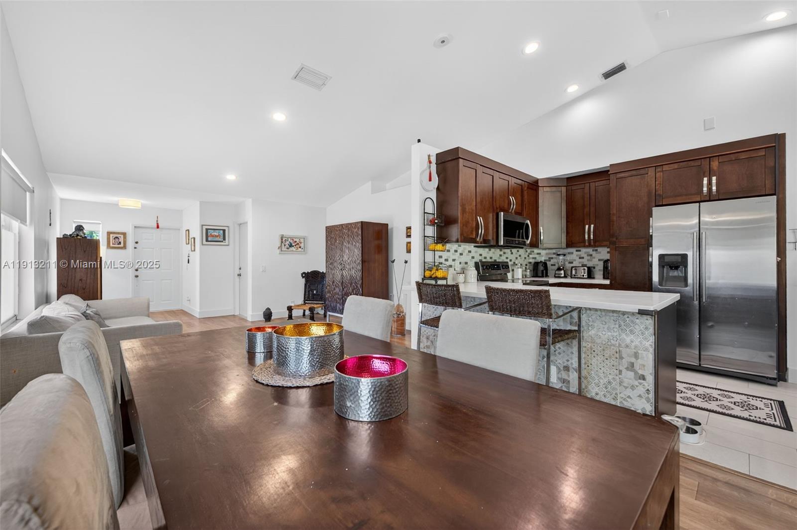 4357 Magnolia Ridge Drive Weston, FL 33331 - Photo 12 of 54 a kitchen with stainless steel appliances granite countertop a refrigerator dining table chairs microwave and cabinets