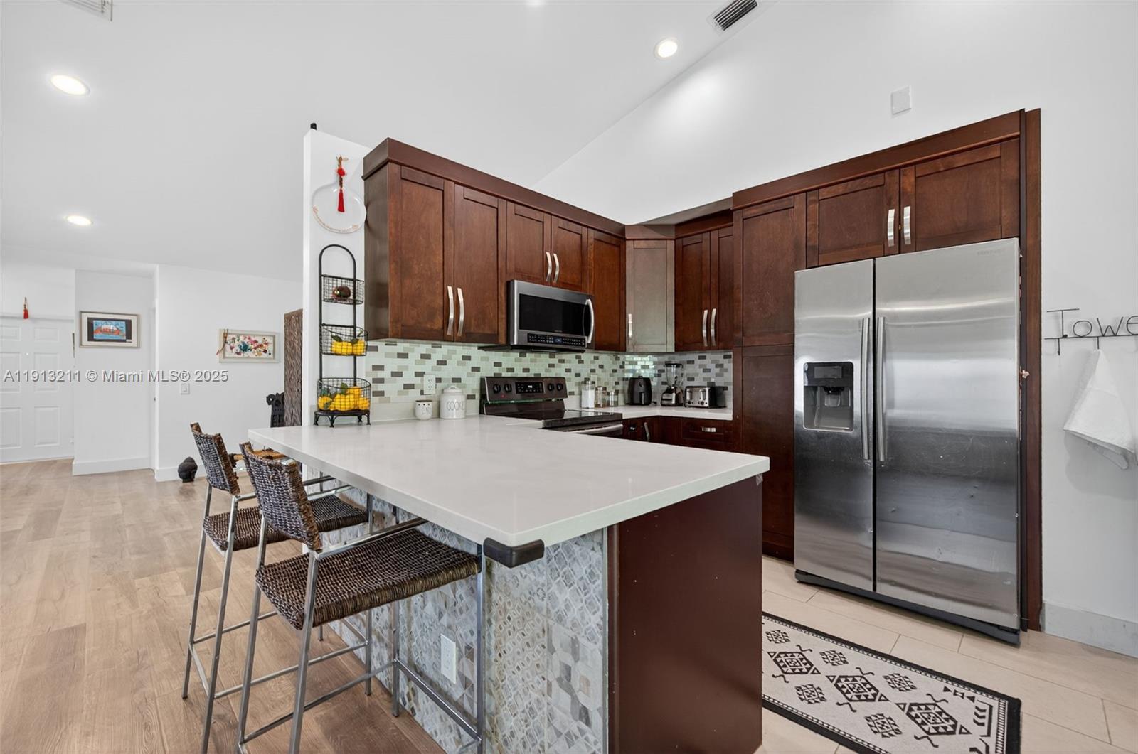 4357 Magnolia Ridge Drive Weston, FL 33331 - Photo 15 of 54 a kitchen with kitchen island a counter top space cabinets and stainless steel appliances