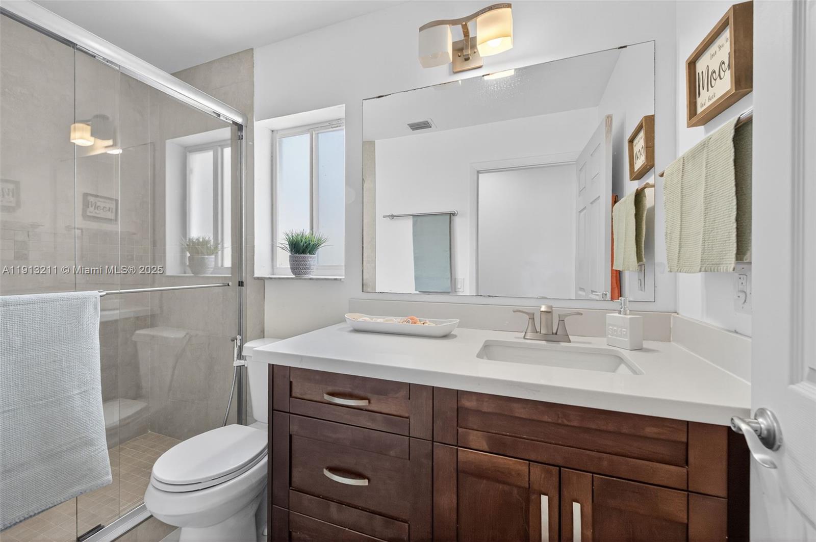 4357 Magnolia Ridge Drive Weston, FL 33331 - Photo 27 of 54 a bathroom with a sink a toilet and a mirror