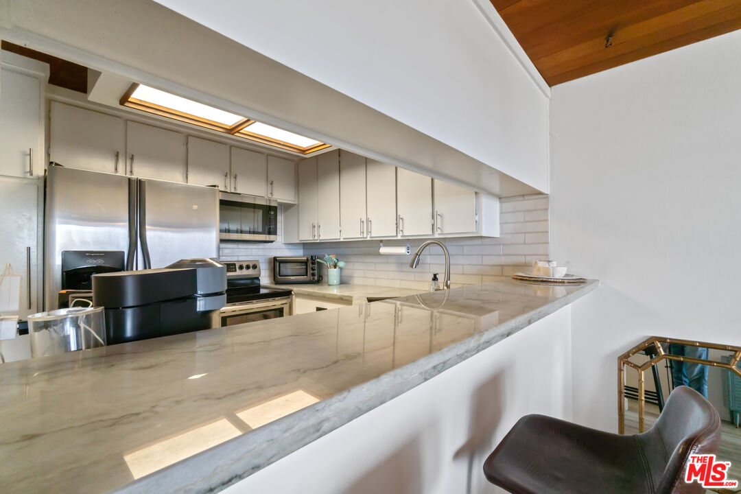 6209 Pacific Avenue, Unit 103 Playa del Rey, CA 90293 - Photo 17 of 40 a kitchen with stainless steel appliances granite countertop a sink a stove and a refrigerator