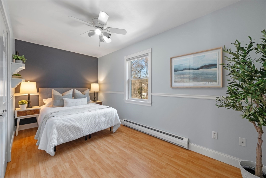 154 R Eastern Avenue Essex, MA 01929 - Photo 19 of 40 a bedroom with a large bed and a chandelier