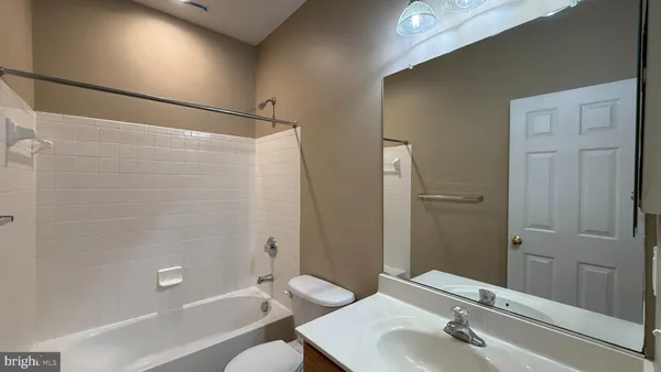 a bathroom with a bathtub shower sink vanity and toilet