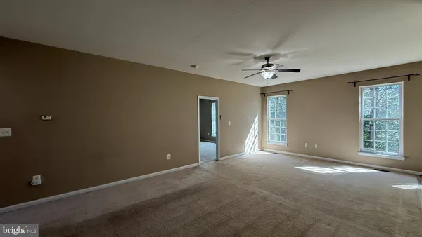 a view of a livingroom with a ceiling fan and window