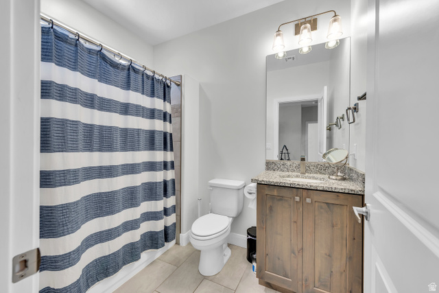 6105 Bunda Way St. George, UT 84790 - Photo 29 of 49 Bathroom featuring a wood-finish vanity with a stone countertop, an undermount sink, and a framed mirror