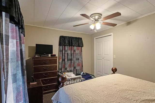 a bedroom with a bed and a flat tv screen on a dresser