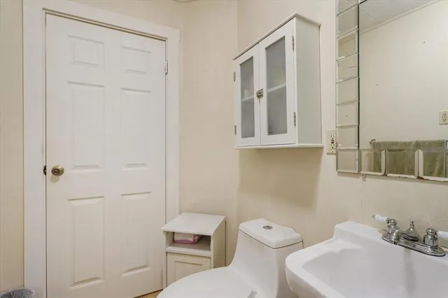 a bathroom with a toilet a sink and mirror