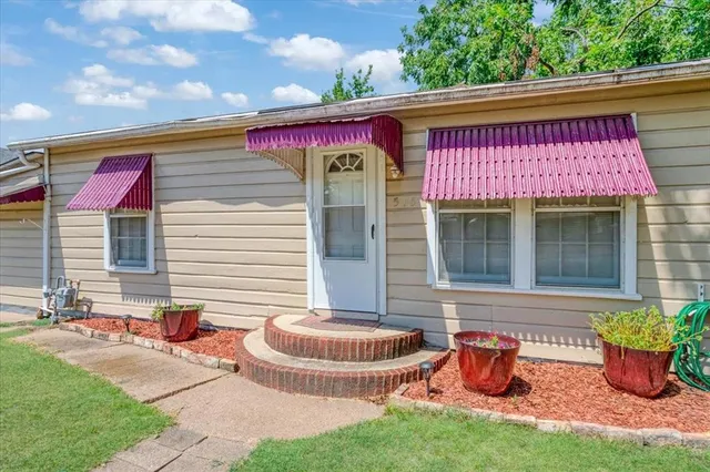 a front view of a house with yard and outdoor seating