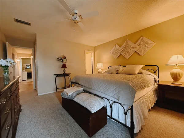 a spacious bedroom with a bed and ceiling fan