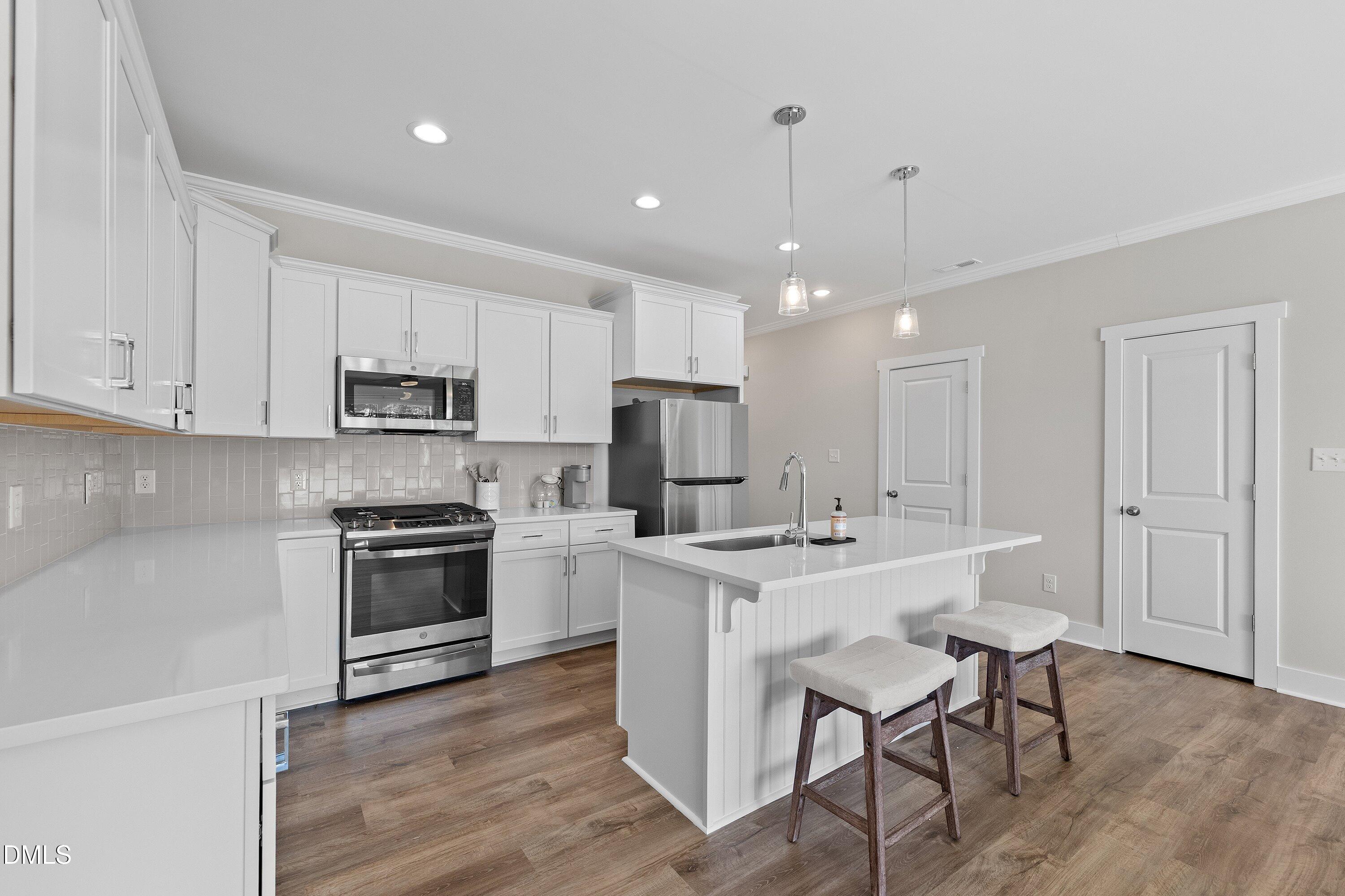 718 Jamescroft Way Rolesville, NC 27571 - Photo 11 of 40 a kitchen with stainless steel appliances granite countertop a stove top oven a refrigerator a sink and a oven with white cabinets