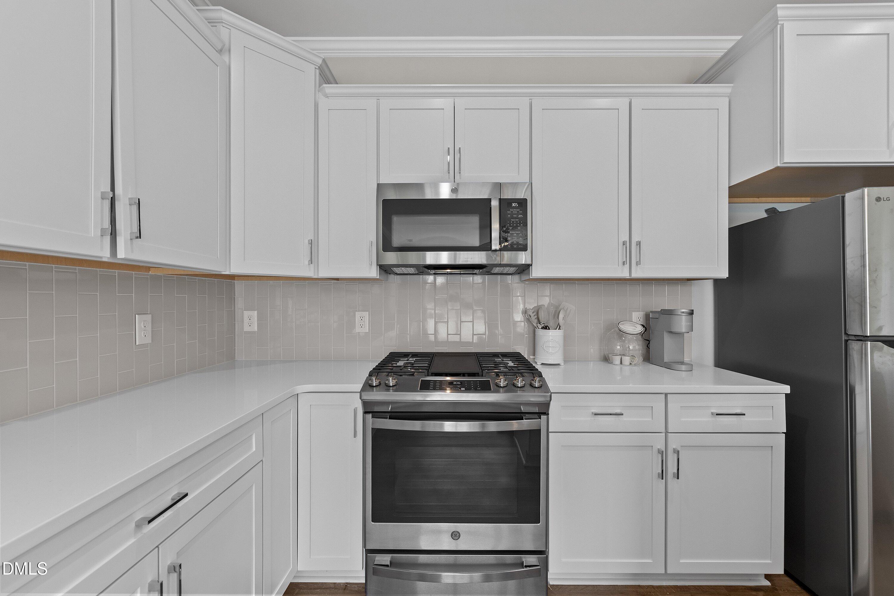 718 Jamescroft Way Rolesville, NC 27571 - Photo 12 of 40 a kitchen with granite countertop white cabinets and stainless steel appliances