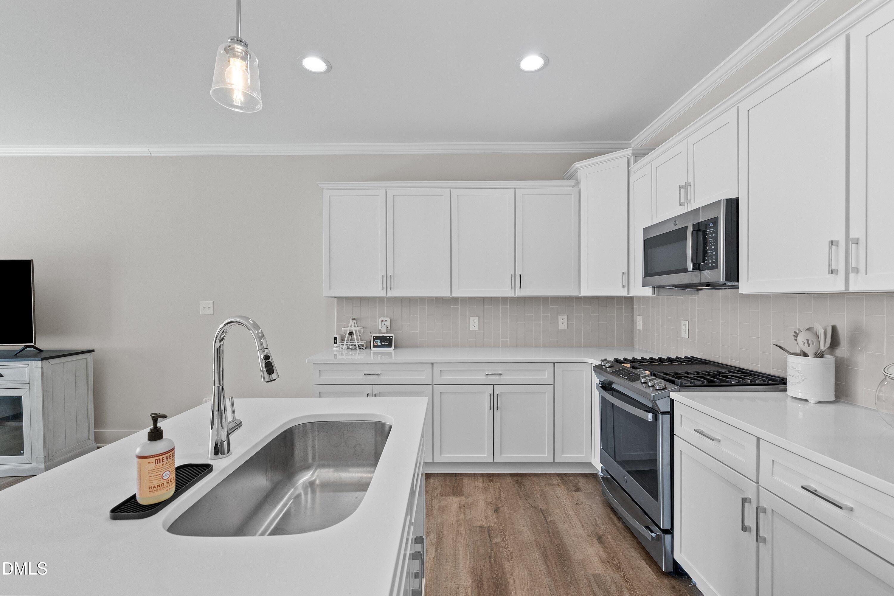 718 Jamescroft Way Rolesville, NC 27571 - Photo 14 of 40 a kitchen with white cabinets a sink stove and microwave