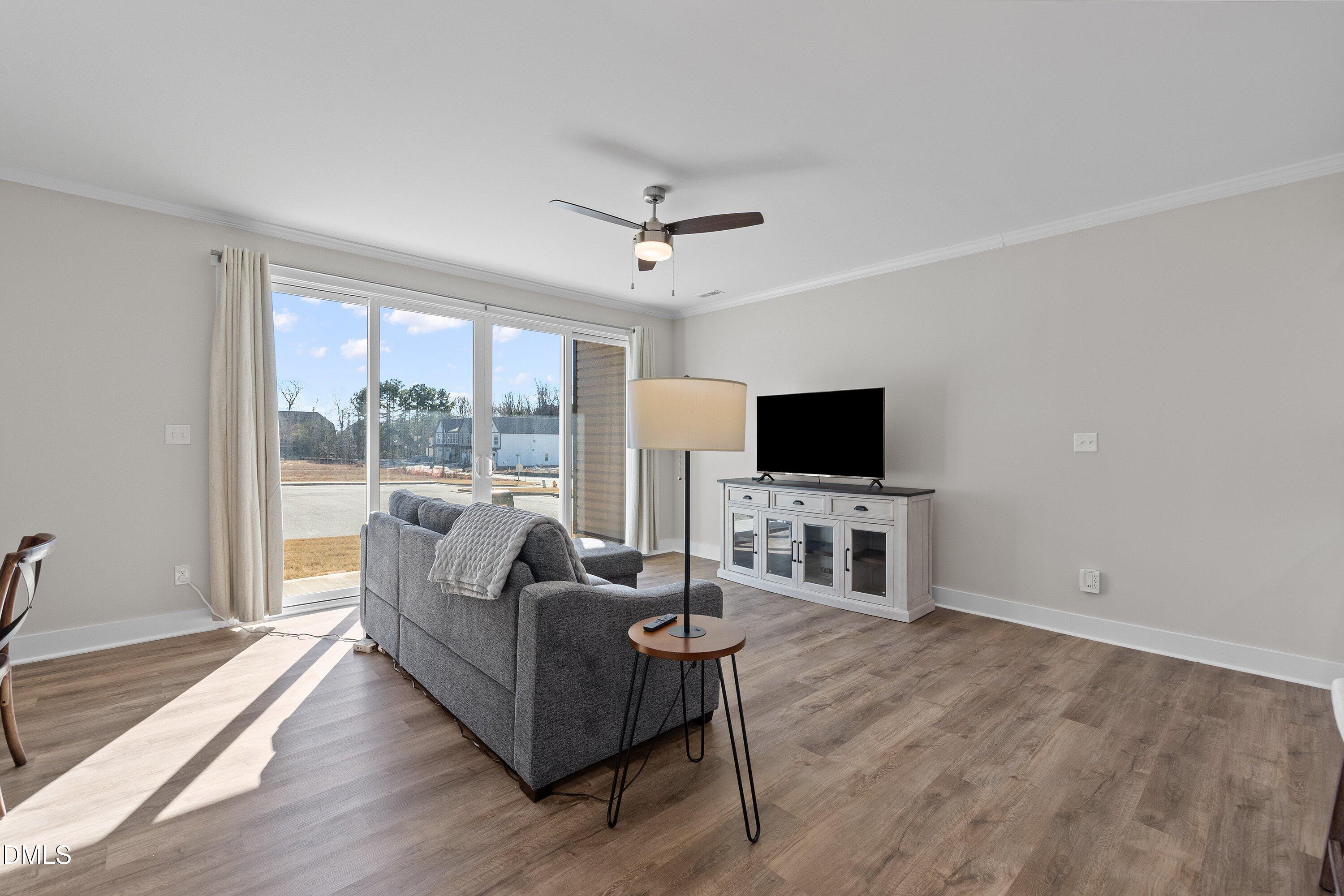 718 Jamescroft Way Rolesville, NC 27571 - Photo 15 of 40 a living room with furniture a flat screen tv and a floor to ceiling window