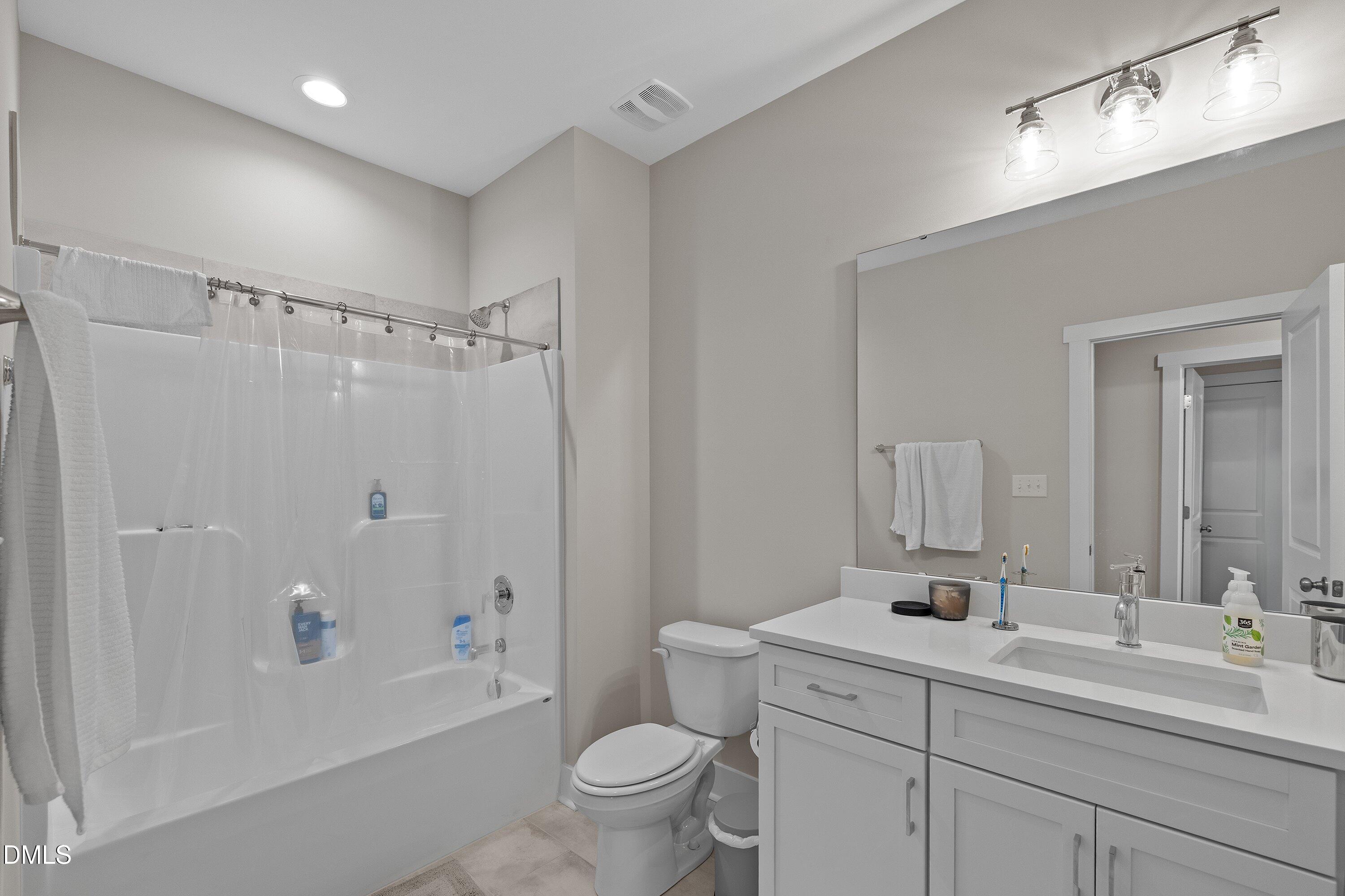 718 Jamescroft Way Rolesville, NC 27571 - Photo 33 of 40 a bathroom with a double vanity sink toilet mirror and shower