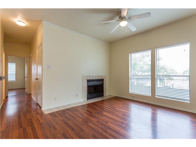 2804 Rio Grande Street, Unit 204 Austin, TX 78705 - Photo 6 of 12 A welcoming living room featuring rich wood flooring, a corner fireplace, and ample natural light.