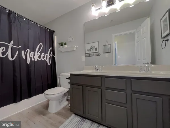 a bedroom with a bed a chandelier and a flat screen tv