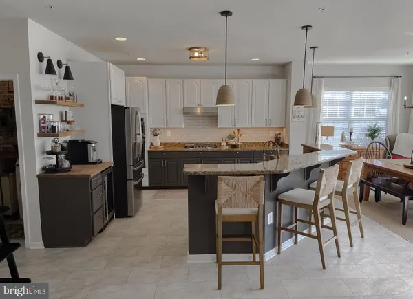 a kitchen with refrigerator a sink and chairs