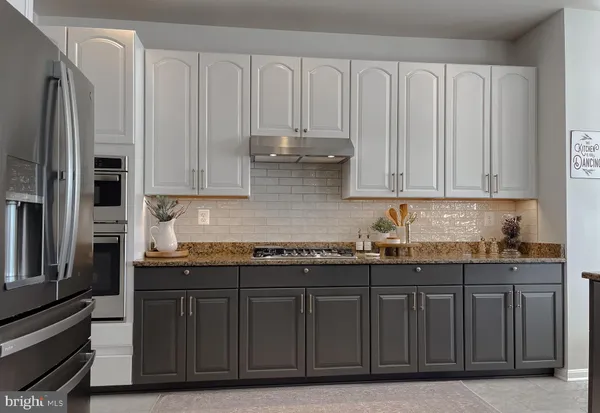a kitchen with stainless steel appliances granite countertop a refrigerator and cabinets