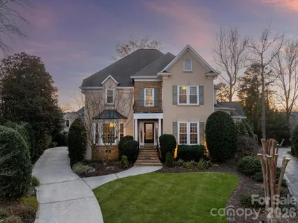 a front view of a house with a yard and potted plants